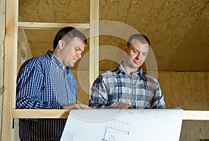 Two builders discussing a building plan