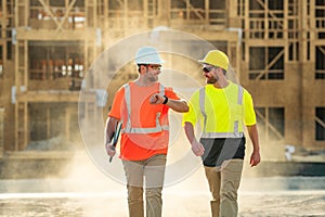 Two builders in a hard hat is busy working on a construction project at a site. A builders workes in a helmet near