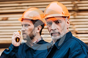 two builders in helmets working outside