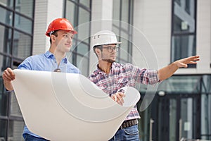 Two builders are looking the area where the construction will be located