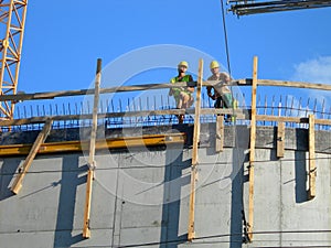 Two builders. Workers on top of a constructed building