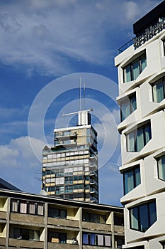 two buildings with different styles of windows on them near each other