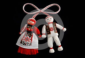 two bulgarian martenitsa dolls in traditional clothing are hanging from a string