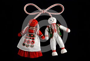 two bulgarian martenitsa dolls in traditional costumes are hanging from a string