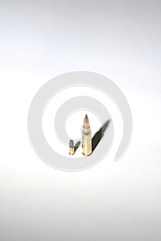 Two bullets of very different calibers on white background