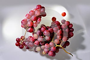 Two Bunches of fresh wine pink grapes falling on a white background big size high resolution