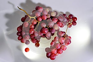 Two Bunches of fresh wine pink grapes falling on a white background big size high resolution