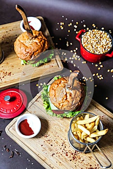 Two Burgers and French Fries on a Cutting Board