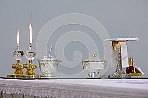 two burning church candles and ostensory on the table