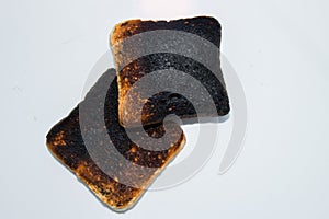 Two burnt toasts - slices of toast bread isolated on a white background.