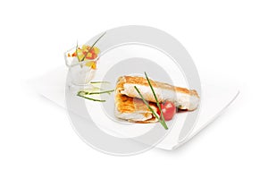 Two burritos on a white dish with sauce