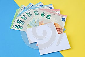 Two business cards and euro money on a colour backrgound