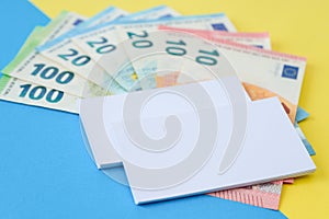 Two business cards and euro money on a colour backrgound