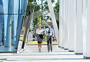 Two business colleagues in formalwear being outside