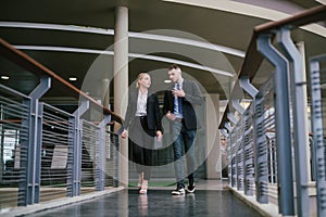 Two business colleagues having discussion with using a digital tablet whilst walking outside office. Communication concept