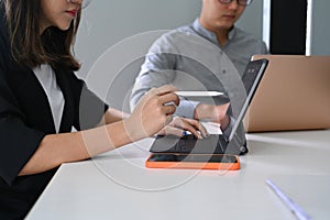 Two business colleagues working with modern gadget in the office.