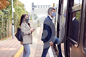 Two Business Commuters Wearing Face Masks Boarding Train At Platform During Pandemic