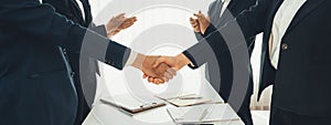 Two business executive shake hand in boardroom for merger and acquisition. Shrewd