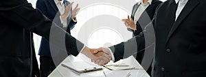 Two business executive shake hand in boardroom for merger and acquisition. Shrewd