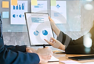 Two business executives analyzing data paper on a clipboard at meeting room