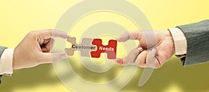 Two business hand holding pieces of a jigsaw puzzle with customer needs text