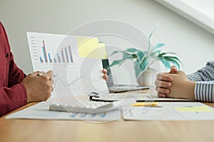 Two business leaders talk about charts, financial graphs showing results are analyzing and calculating planning strategies,