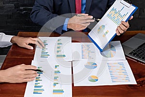 Two business leaders talk about charts, financial graphs showing results are analyzing and calculating planning strategies,