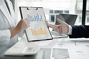 Two business leaders talk about charts, financial graphs showing results are analyzing and calculating planning strategies,