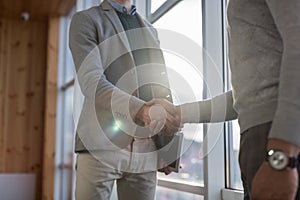 Two Business Man Shake Hand Agreement Coworking Center Business Team Coworkers Stand in front Big Panoramic Window photo