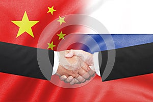 Two business man shakehand on china and russian flag