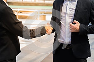 Two business man shaking hands for demonstrating their agreement to sign agreement or contract between their firms / com