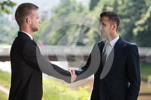 Two Business Man Shaking Hands In Park