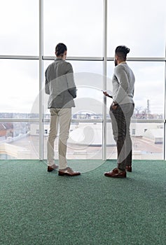 Two Business Man Using Tablet Computer Coworking Center Business Team Coworkers Stand in front Big Panoramic Window