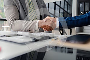 Two business men shake hands, Two businessmen are agreeing on business together and shaking hands after a successful negotiation.