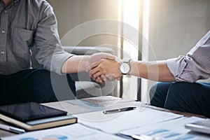 Two business men shaking hands during a meeting to sign agreement and become a business