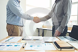 Two business men shaking hands during a meeting to sign agreement and become a business