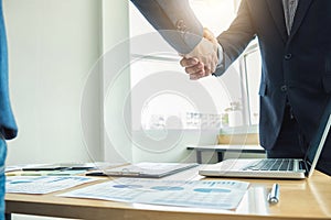 Two business men shaking hands during a meeting to sign agreement and become a business