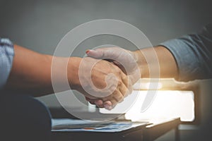 Two business men shaking hands during a meeting to sign agreement and become a business