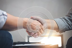 Two business men shaking hands during a meeting to sign agreement and become a business