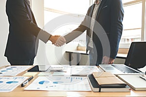 Two business men shaking hands during a meeting to sign agreement and become a business partner, enterprises, companies, confident photo