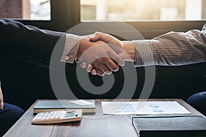 Two business men shaking hands during a meeting to sign agreement and become a business