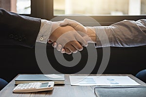 Two business men shaking hands during a meeting to sign agreement and become a business