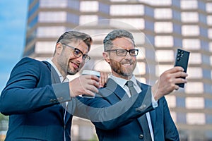 Two business men using phone outdoor. Planning of two business teams strategy. Two business men teams strategic approach