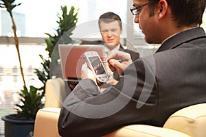 Two business men working with laptop & palmtop in the office environment. photo