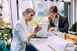 Two business partners discussing working plans while using tablet pc in cafe bar