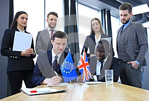 Two business partners signing a document. The European Union and Great britian. Brexit.