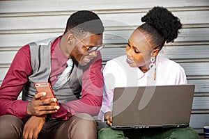 Two business partners using a mobil phone and laptop