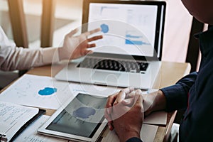 Two business partnership coworkers discussing a financial planning graph and company during a budget meeting in office room