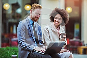 Two business people in an informal conversation in front of a busuness building