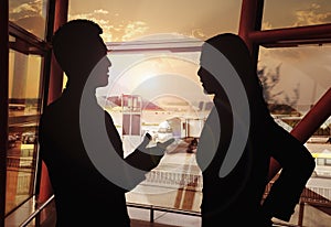 Two business people talking in the airport, Silhouette